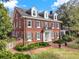 Stunning red brick two-story home with black shutters, white columns, and a brick walkway at 721 Delaney Ave, Orlando, FL 32801