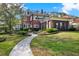 Stunning red brick home featuring a manicured lawn, stone walkway, and screened in porch at 721 Delaney Ave, Orlando, FL 32801