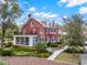 Stately red brick home with screened porch, balcony, manicured lawn and stone walkway at 721 Delaney Ave, Orlando, FL 32801