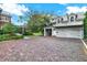 Two car garage with brick driveway, carriage doors, exterior stairs and dormer windows at 721 Delaney Ave, Orlando, FL 32801