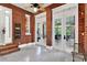 Inviting sunroom with brick walls, tile flooring, and French doors leading to another outdoor space at 721 Delaney Ave, Orlando, FL 32801