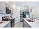 Bright kitchen with gray cabinets, stainless steel appliances, and quartz countertops at 7821 Waterscape Dr, Groveland, FL 34736