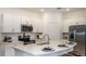 Modern kitchen featuring stainless steel appliances, white cabinets, and a large island at 7823 Waterscape Dr, Groveland, FL 34736