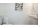 Simple powder room with toilet, sink, and decorative art at 7823 Waterscape Dr, Groveland, FL 34736