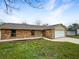 Charming exterior view of brick home with manicured lawn, and a two car garage at 832 Yellowbird Ave, Deltona, FL 32725