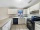 Well-lit kitchen boasts white cabinetry, granite countertops, and modern black appliances at 832 Yellowbird Ave, Deltona, FL 32725