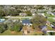 Aerial view of a house with a fenced backyard, patio seating, and surrounded by mature trees at 970 Picasso Ave, Deltona, FL 32738