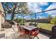 Outdoor screened lanai with dining set, with firepit and grill in a well-manicured yard at 970 Picasso Ave, Deltona, FL 32738