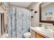 Well-lit bathroom with seashell-themed shower curtain, white vanity, and a framed mirror at 970 Picasso Ave, Deltona, FL 32738