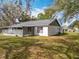 A sprawling backyard featuring a screened-in porch and partial shade from mature trees, perfect for outdoor living at 10238 Summit Square Dr, Leesburg, FL 34788