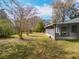 This is a view of the backyard, showing a screened in lanai and the green grass and foliage at 10238 Summit Square Dr, Leesburg, FL 34788