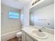 Bright bathroom featuring a bathtub, toilet, sink, and mirror at 10238 Summit Square Dr, Leesburg, FL 34788