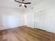 Bedroom with wood-look floors, ceiling fan, and large closet at 10238 Summit Square Dr, Leesburg, FL 34788