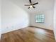 Bedroom with wood-look flooring, ceiling fan, and a window for natural light at 10238 Summit Square Dr, Leesburg, FL 34788