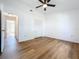 Bedroom with wood-look floors, ceiling fan, and access to other rooms at 10238 Summit Square Dr, Leesburg, FL 34788