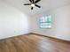 Bedroom with wood-look flooring, ceiling fan, and a window at 10238 Summit Square Dr, Leesburg, FL 34788