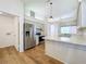 Bright kitchen with stainless steel appliances, white cabinets, and wood-look flooring at 10238 Summit Square Dr, Leesburg, FL 34788