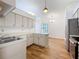 Functional kitchen with stainless steel appliances, white cabinetry, and wood-look floors, providing ample counter space at 10238 Summit Square Dr, Leesburg, FL 34788