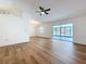 Open floor plan living room featuring wood-look floors, a ceiling fan, and sliding glass doors to the lanai at 10238 Summit Square Dr, Leesburg, FL 34788