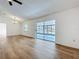 Bright living room featuring wood-look floors, a ceiling fan, and sliding glass doors to the screened patio at 10238 Summit Square Dr, Leesburg, FL 34788