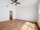 Main bedroom featuring neutral walls, wood-look flooring, fan, and en suite bathroom at 10238 Summit Square Dr, Leesburg, FL 34788