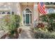 Inviting front entrance featuring a wreath-adorned teal door, sidelights, and blooming plants for added charm at 107 Springhurst Cir, Lake Mary, FL 32746