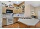 Well-lit kitchen featuring wood floors, neutral countertops, white appliances, and ample cabinet space at 107 Springhurst Cir, Lake Mary, FL 32746