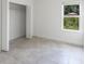 Tiled bedroom featuring an open closet and a window offering natural light and backyard views at 13220 Sw 85Th Cir, Ocala, FL 34473