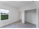 This tiled bedroom features an open closet and window overlooking backyard greenery at 13220 Sw 85Th Pl, Ocala, FL 34473