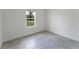 Bright bedroom featuring gray tile floor, white trim, and a window offering a view of the outdoors at 13220 Sw 85Th Cir, Ocala, FL 34473