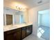 Bathroom featuring double sink vanity with dark cabinets and light countertops at 14575 Crestavista Ave, Clermont, FL 34714