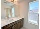 Bathroom vanity featuring double sinks, white countertops, and a large mirror at 14575 Crestavista Ave, Clermont, FL 34714