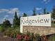 Community sign featuring 'Ridgeview' on a white background with a stone base at 14575 Crestavista Ave, Clermont, FL 34714