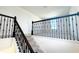 Elegant staircase featuring dark wood railings, neutral carpet, and natural light from a window at 14575 Crestavista Ave, Clermont, FL 34714