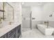 Sleek bathroom featuring a walk-in shower, soaking tub, vanity with gold fixtures, and marble accents at 1531 Lake Baldwin Ln, Orlando, FL 32814