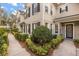 Townhome exterior with black shutters on the windows, lush landscaping, and a walkway at 1531 Lake Baldwin Ln, Orlando, FL 32814