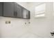 Functional laundry room with overhead cabinets, white walls, and tile flooring offering storage and practicality at 1531 Lake Baldwin Ln, Orlando, FL 32814