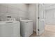 Well-lit laundry room with white appliances and a wire shelf for storage at 1630 Laia Rd, Haines City, FL 33844