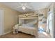 Bright bedroom featuring a bunk bed with a ladder and shelving, and a bedside table with a lamp at 1657 Cherry Ridge Dr, Lake Mary, FL 32746