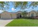 Charming home featuring a three-car garage, well-maintained lawn, and lush landscaping at 1657 Cherry Ridge Dr, Lake Mary, FL 32746