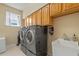 Laundry room featuring a side-by-side washer and dryer, cabinet, and a sink near the window at 1657 Cherry Ridge Dr, Lake Mary, FL 32746