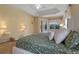 Relaxing main bedroom featuring a tray ceiling, access to the pool, and two bedside tables with lamps at 1657 Cherry Ridge Dr, Lake Mary, FL 32746