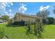 Landscaped side yard featuring green grass, lush bushes, and a black metal fence at 1657 Cherry Ridge Dr, Lake Mary, FL 32746