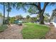 Spacious backyard featuring a playset, swing, and seating area under a large shade tree at 1804 Wind Willow Rd, Belle Isle, FL 32809