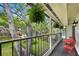 Relaxing balcony view with red chairs and table, overlooking the lush green yard and mature trees at 1804 Wind Willow Rd, Belle Isle, FL 32809