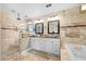 Luxurious bathroom featuring double sink vanity, granite counters, and a spacious walk-in shower with travertine tile at 1804 Wind Willow Rd, Belle Isle, FL 32809