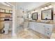 Beautiful bathroom featuring double sink vanity with granite counters and spacious walk-in shower with stone flooring at 1804 Wind Willow Rd, Belle Isle, FL 32809