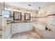 Spa-like bathroom with travertine tile, double vanity, soaking tub, and walk-in shower for a luxurious retreat at 1804 Wind Willow Rd, Belle Isle, FL 32809