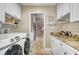 Bright laundry room with granite counters, white cabinets, stainless sink, and washer and dryer at 1804 Wind Willow Rd, Belle Isle, FL 32809