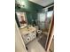 Classic bathroom featuring tiled floors, a shower, toilet, sink, mirror, and a dark green wall at 1808 4Th Se Ct, Winter Haven, FL 33880